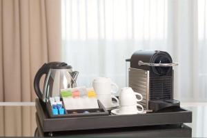 格罗宁根格罗宁根NH酒店的一个带咖啡壶和茶几上的杯子的托盘
