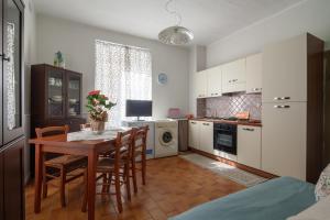 TresanaB&B Il Tempo Del Vento-Camere e Appartamenti的一间带桌椅的厨房和一间带微波炉的厨房