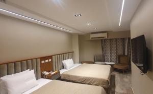 开罗Garden City Plaza Hotel的酒店客房设有两张床和一台平面电视。