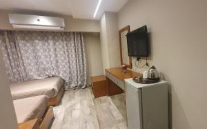 开罗Garden City Plaza Hotel的小房间设有床铺和电视