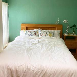 济州市Gawkji House 곽지집的卧室内的一张带白色床单和枕头的床
