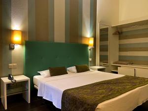 圣玛丽亚Ouril Pontao Hotel的一间卧室配有一张大床和绿色床头板