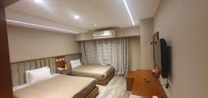 开罗Garden City Plaza Hotel的酒店客房设有两张床和电视。