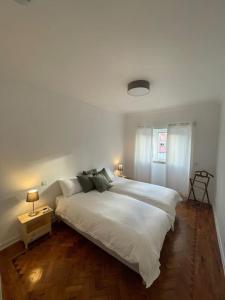 里斯本ASF Home的卧室配有一张白色大床和两盏灯。