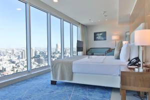 安曼Coral Tower Hotel by Hansa的卧室设有一张白色大床和大窗户