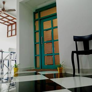 古瓦哈提VIAN INN的一个带黑椅的房间的绿色门