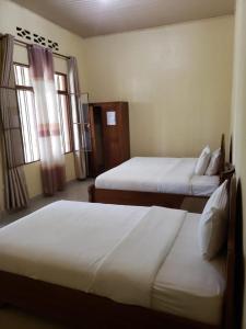 RwumbaEAR KEN BARHAM GUESTHOUSE的酒店客房带两张床和两个窗户