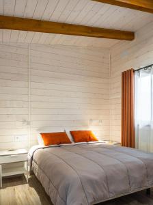 坎普罗东坎普罗东山谷露营酒店的一间卧室配有一张带橙色枕头的大床