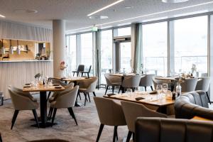 卑尔根斯堪迪克欧内酒店的餐厅设有桌椅和窗户。