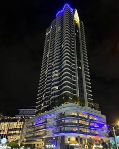 哥打巴鲁Rizz Residence Troika KB的一座高大的建筑,晚上有蓝色的灯光