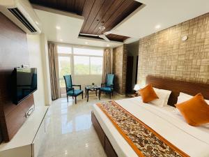 古尔冈Hotel Dayal Regency near Sushant Lok Sector 29 Gurgaon - Couple Friendly的一间卧室配有一张床、一台电视和一张桌子