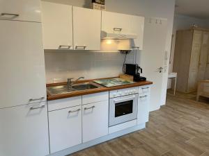 布伦瑞克Tolles Apartment in idyllischer ruhiger Lage的厨房配有白色橱柜和水槽
