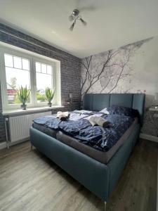 格洛米茨Ferienhaus Markus - Grömitz OT Brenkenhagen的卧室里一张蓝色的床,卧室里设有砖墙
