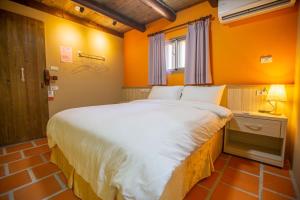 金湖镇金门泰上皇古厝民宿的橙色墙壁的客房内的一张大床