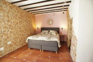 阿尔啼La Cueva的一间卧室设有一张床和石墙