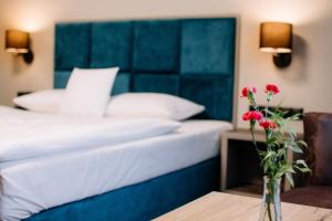 绿山城锡隆纳葛拉鲁本酒店的一间卧室配有一张床,一个花瓶摆放在桌子上