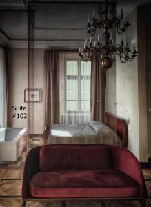 克拉科夫罗萨博得酒店的一间卧室配有一张床和一张红色的沙发