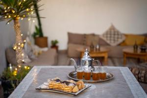 Tamraght Ou FellaCasa Janoub Morocco的茶壶和一盘食物的桌子