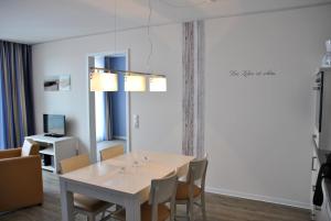 埃肯弗德Apartmenthaus Hafenspitze Ap 42 "Segler", mit Sauna, Blickrichtung offene See - a72332的一间带桌椅的用餐室