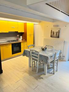 泰尔莫利La dimora sul porto的厨房配有桌椅和黄色橱柜