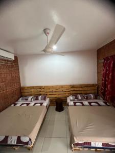 马六甲Ujud Sepakat Homestay的配有吊扇的客房内的两张床