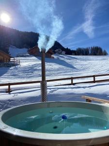 南达Ski in out Swiss Alps Chalet Charelle by Jolidi的雪中的一个热水浴缸,蒸汽从外面出来