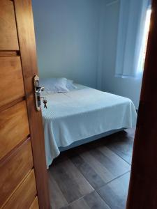 伊瓜苏Casa Silvano's II的卧室配有带白色床单的床和门。