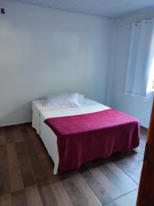 伊瓜苏Casa Silvano's II的卧室配有白色床和紫色毯子