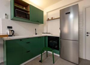 贝尔谢巴Boutique Central old town Apartment的厨房配有绿色橱柜和不锈钢冰箱