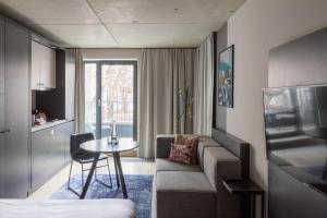 慕尼黑numa I Stark Rooms & Apartments的带沙发和桌子的小客厅