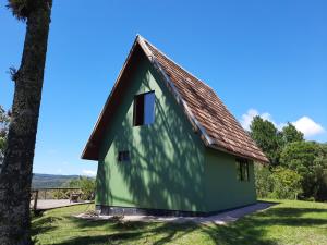 兰舒凯马杜Nosso Pátio - Chalé na Montanha的棕色屋顶的绿色房子