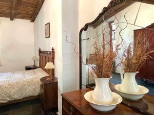 CañameroLa Alberguería complejo rural的卧室配有木桌上的两只白色花瓶
