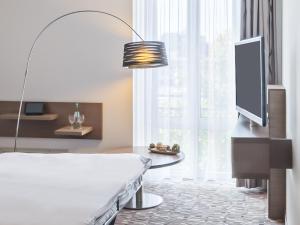 哥廷根哥廷根丽笙公园酒店的客厅配有床和平面电视