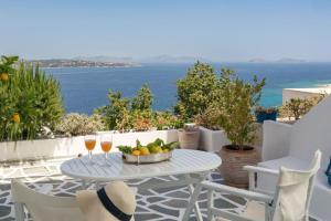 斯派赛斯Spetses Sea View Luxury House的一张桌子,上面放着一碗水果和两杯葡萄酒