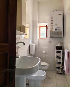 皮昂比诺Casa dei MoMi的白色的浴室设有水槽和卫生间。
