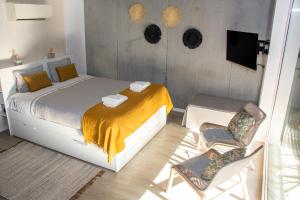 阿威罗Casa das Falcoeiras - Estúdio com terraço privado的一间卧室配有一张床和一对椅子