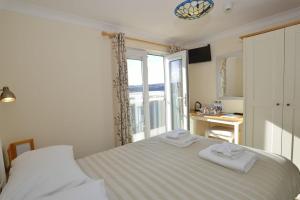海尔Sandy Bay Apartment, St Ives Bay, Hayle的一间卧室配有一张床,上面有两条毛巾