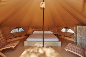 帕尔斯玛斯帕托哈斯公园营地平房度假村的帐篷内的一张床位,设有两个窗户