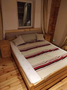 加沃尔金卡Gościniec Śliwkula的铺有木地板的客房内一张大床