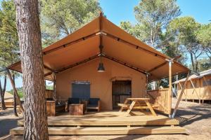 帕尔斯玛斯帕托哈斯公园营地平房度假村的一个带桌子和树的帐篷