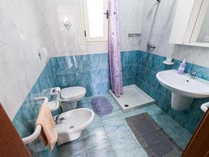 托雷圣乔万尼乌Appartamenti Vista Mare Salento的一间带水槽、卫生间和淋浴的浴室