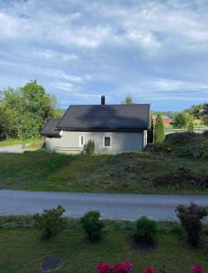 维尼斯拉Familievennlig leiligheten leies ut på Sørlandet.的山坡上白色的房子,屋顶黑色