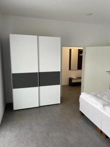 舍纳贝克Ferienhof Elbaue的一间卧室配有床和白色及黑色的橱柜。