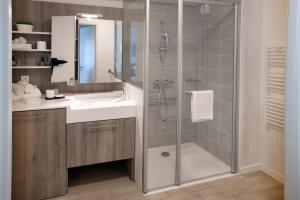 苏瓦松Domitys Le Domaine d'Agate的带淋浴、盥洗盆和镜子的浴室