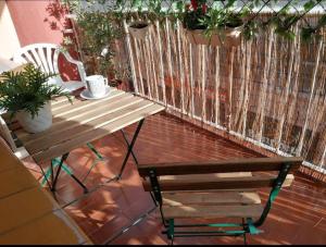 帕拉莫斯Spacious family flat centrally located.的种植了植物的阳台的长凳和桌子