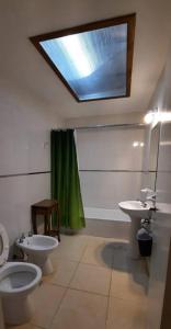 马德普拉塔Casa en Bosque Peralta Ramos的浴室设有2个卫生间、水槽和天窗。