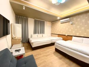台中市逢甲猪小窝的酒店客房,设有两张床和一张沙发