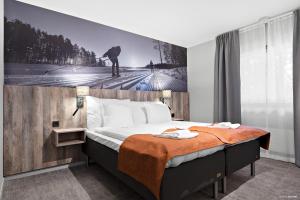 莫拉First Camp Moraparken Hotel的一间卧室,配有一张带滑雪者照片的床