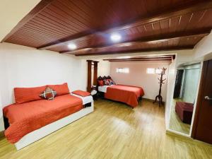 巴尼奥斯Hermoso apartamento en Baños de Agua Santa的一间卧室设有两张床和窗户。