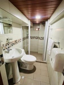 巴尼奥斯Hermoso apartamento en Baños de Agua Santa的浴室配有白色卫生间和盥洗盆。